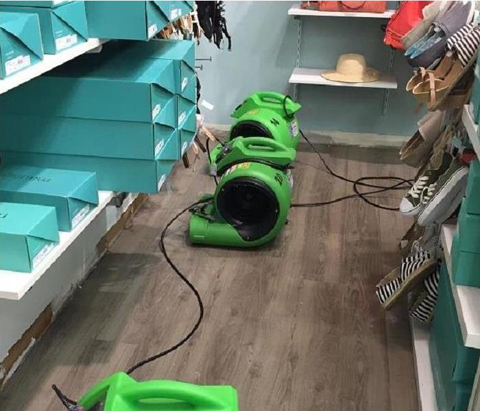 Floor in a mall store with SERVPRO green equipment.