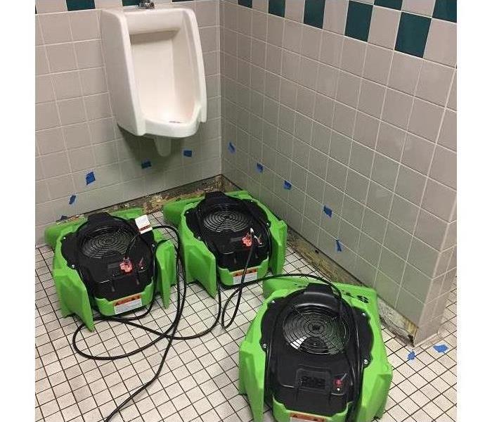 Urinal and SERVPRO green equipment.